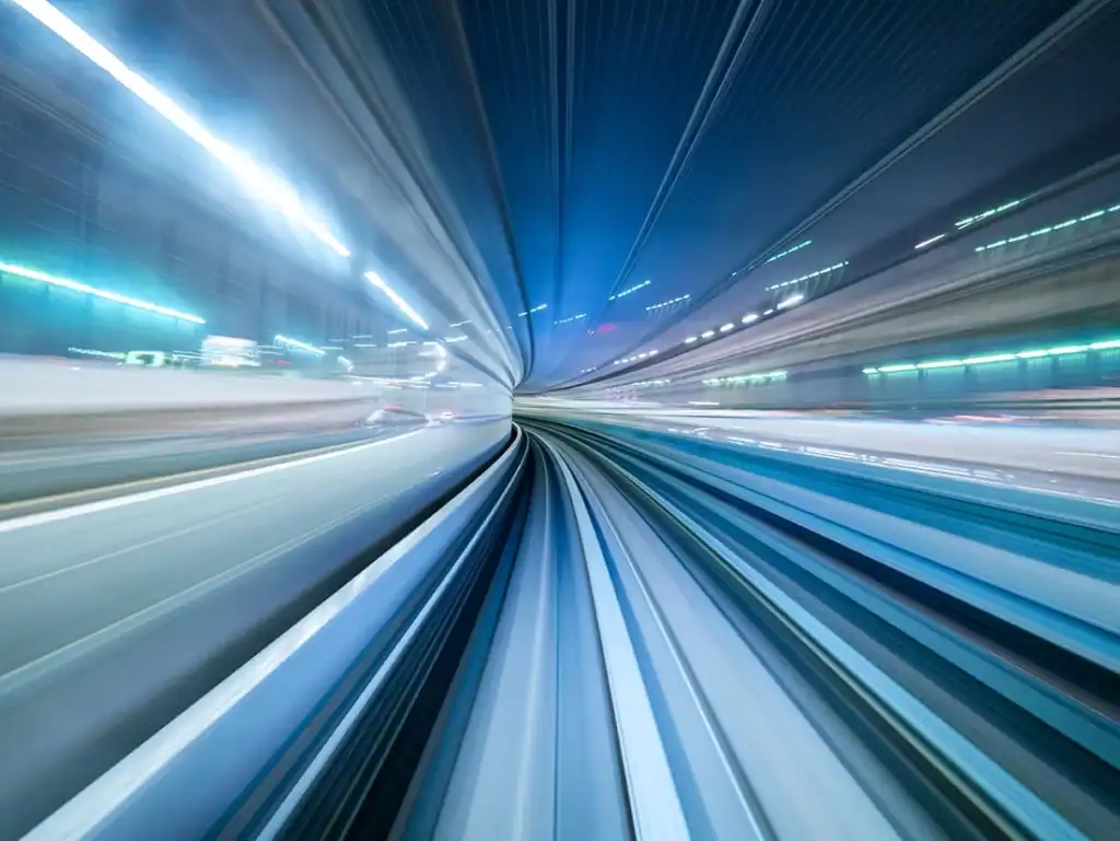Fast-moving train on high-speed rail with light trails at night.